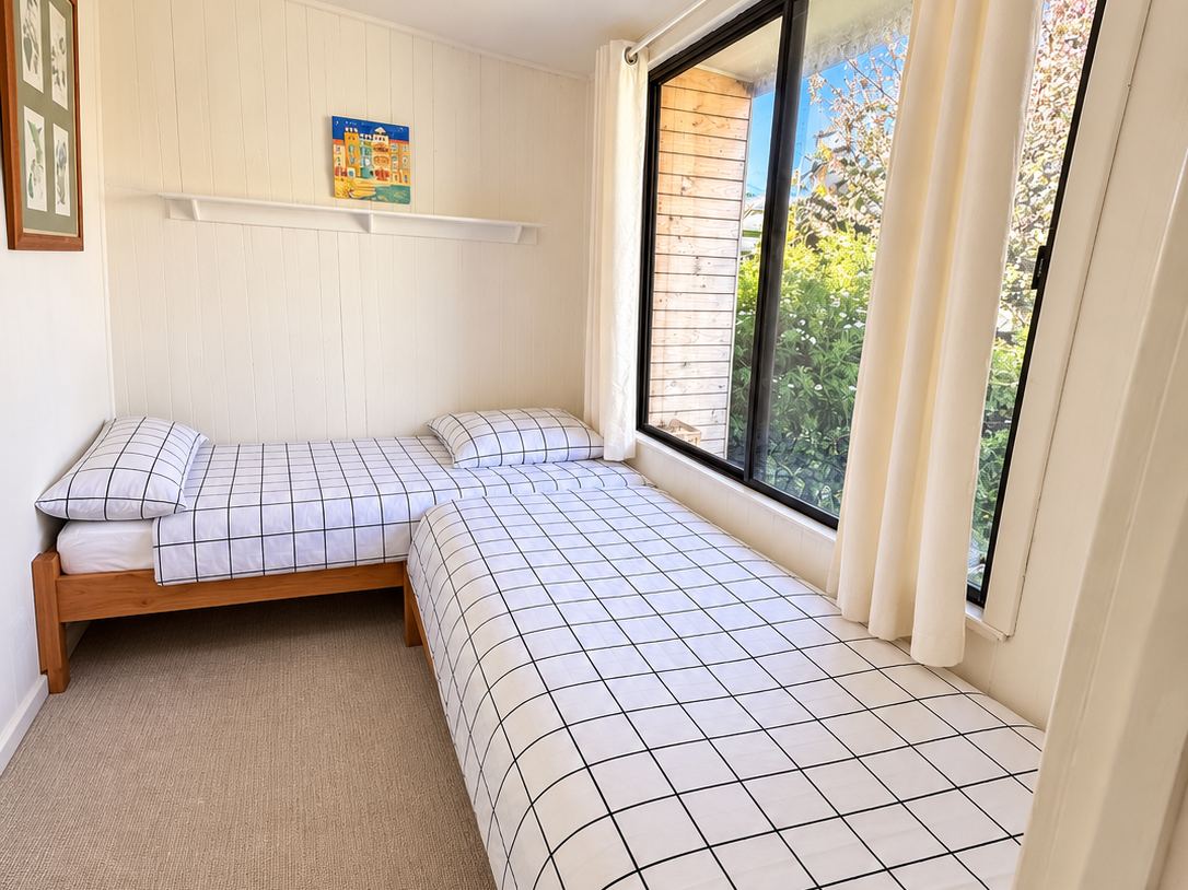 The Cubby, kids room with two single beds and garden window at Sandy Feet Retreat