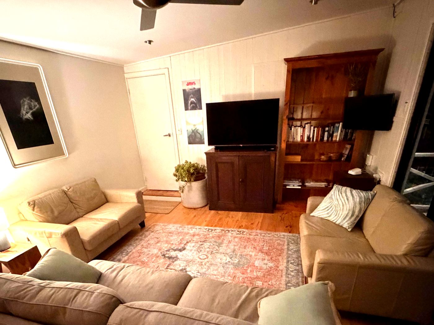 Living room with sofas, rug and bookshelf at Sandy Feet Retreat holiday house